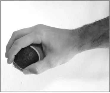 Photo: hands curved over the keys while holding a tennis ball in each hand
